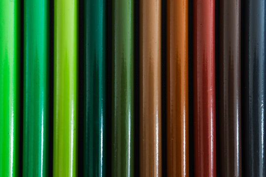 close-up of colored pencil barrels neatly lined up in colour wheel order, concept of creativity and education