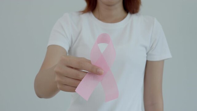 Woman hold pink ribbon breast cancer awareness. Female health check consciousness. international Women Day and World Cancer Day. sign cancer, Symbolic, health care, support patients, timely diagnosis