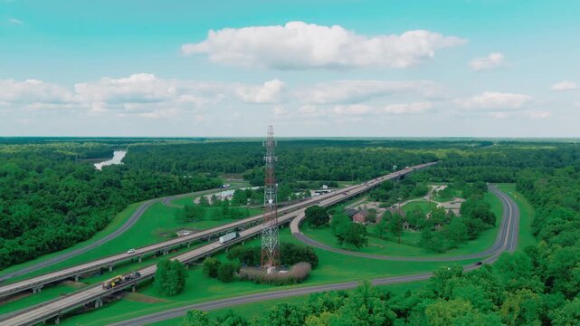 Tall lattice communications tower beside the elevated I-10 highway over the Louisiana Atchafalaya swamp, a telecom mast standing along the basin bridge corridor.