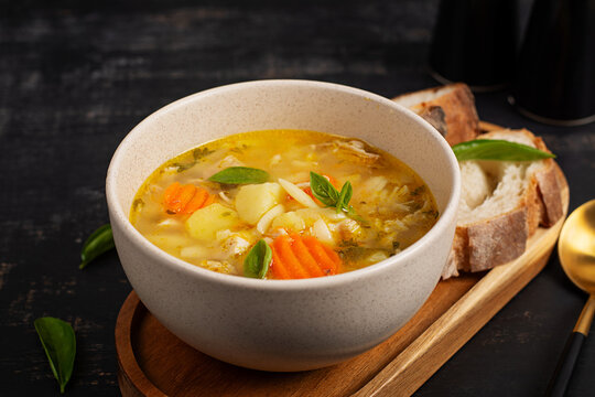Rustic Chicken Orzo Soup in Bowl on Dark Background