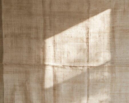 Handwoven natural linen cloth with slubbed texture and morning light, a neutral fabric background for organic product packaging and minimalist food styling