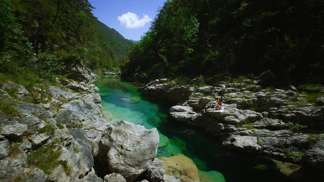 Clear emerald green mountain river with summer tourists resting at Pozze Smeraldine. Dolomites, Italy
