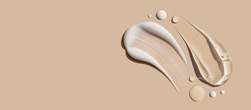 samples of cosmetic care products smear of cream serum texture on a beige background