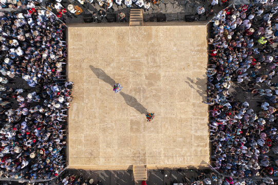 Aerial view of Kurpites dancers performing on a wooden stage surrounded by a large crowd of spectators in Nuevo San Juan Parangaricutiro, Michoacan, Mexico.