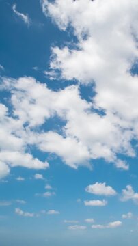 Peaceful daytime sky time-lapse with soft white clouds flowing in a deep blue atmosphere.