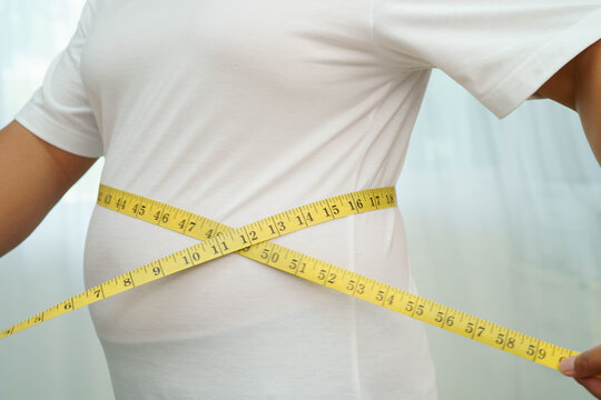 Asian woman with fat belly big size overweight and obesity with measure tape.