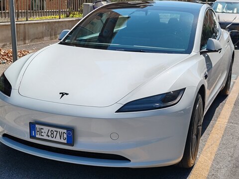 Rome, Italy - August 10, 2026, a Tesla car, a vehicle powered exclusively by electricity, designed and manufactured by Tesla, charging at a charging station.