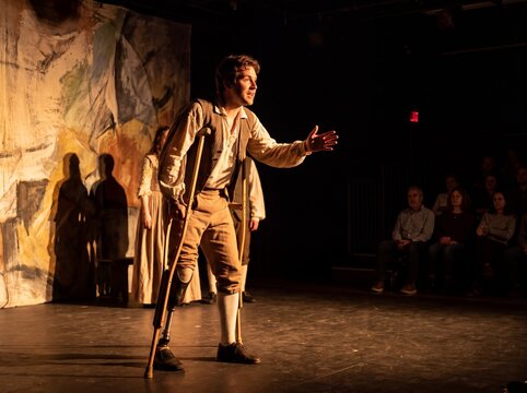 Actor on Stage with Crutches Delivering Dramatic Performance