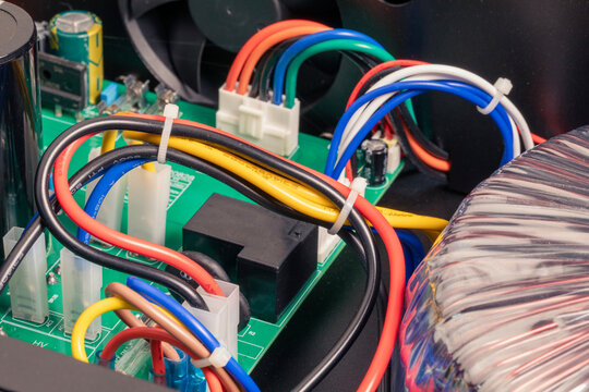 Wires with components in electronic circuit board, power supply transformer of amplifier, close-up, macro shot