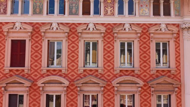 Drone pans along the richly decorated facade of a historic palace in Genoa, Italy.