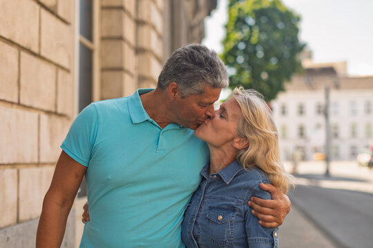 Couple sharing a kiss on a city sidewalk