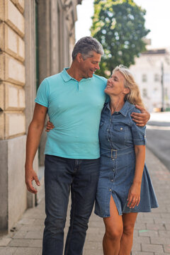 Full length portrait of a couple walking a city street