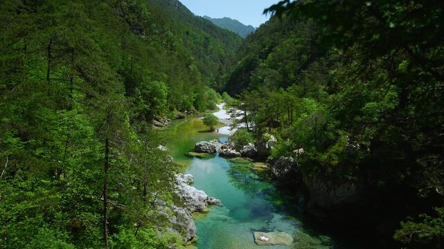 Deep turquoise river mountain rock pool inside a scenic canyon at Pozze Smeraldine. Dense green forest