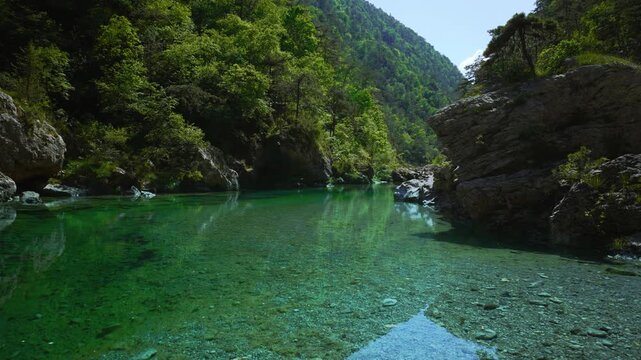 Transparent turquoise river pool with limestone cliffs and rocks at Pozze Smeraldine in Northern Italy