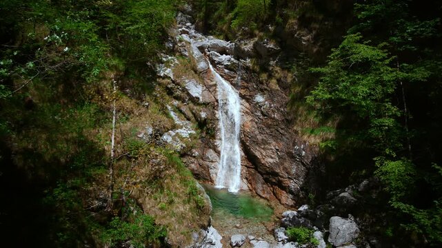 Pristine turquoise river pool with a moving mountain waterfall as an infinite loop cinemagraph.