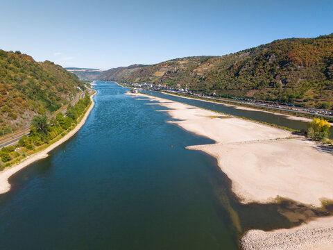 Aerial view of the Rhine river with low water levels and exposed dry riverbeds in the Upper Middle Rhine Valley near Kaub, Rhineland-Palatinate, Germany.