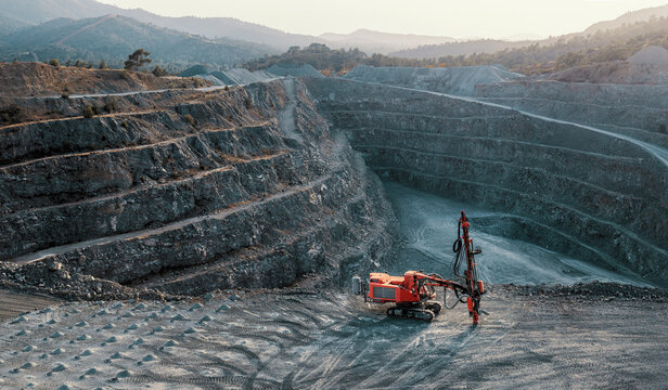 Open Pit Quarry with Rock Drilling Machine and Terraced Mine Landscape