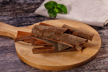 Cinnamon sticks on wooden cutting board with mint leaves © Andrei Starostin