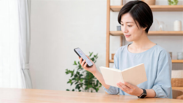 スマートフォンを確認しながら本を読む女性