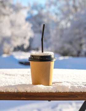 Takeaway Coffee Cup with Straw Left in Fresh Snow