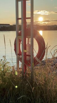Red Lifebuoy by the Sea at Sunset Vertical Video