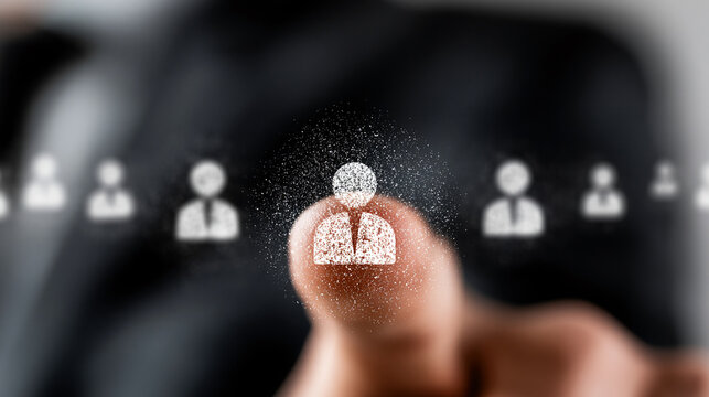 Businessman touching a dissolving digital employee icon that disperses into particles to symbolize personnel loss or organizational change.