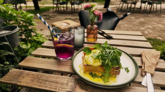 Eggs Benedict brunch with sangria on rustic outdoor caf&eacute; table &mdash; perfect for brunch menu branding, garden caf&eacute; lifestyle content, and weekend dining marketing