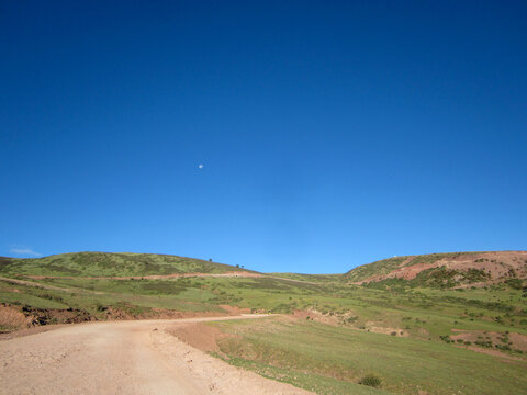 Clear blue sky over a vast grassy countryside landscape