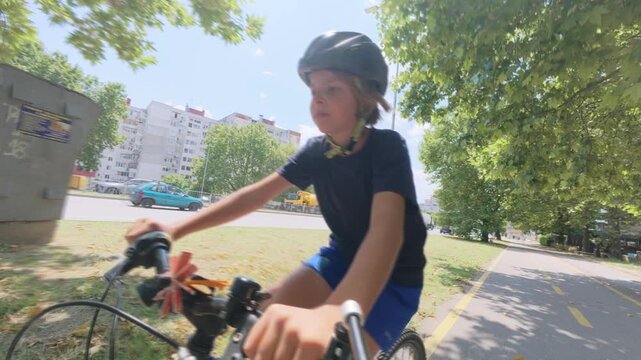 Young Boy Riding Bicycle on City Bike Lane POV