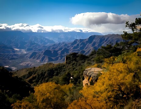 Stunning scenic view of snow-capped mountains over a deep canyon valley in autumn.