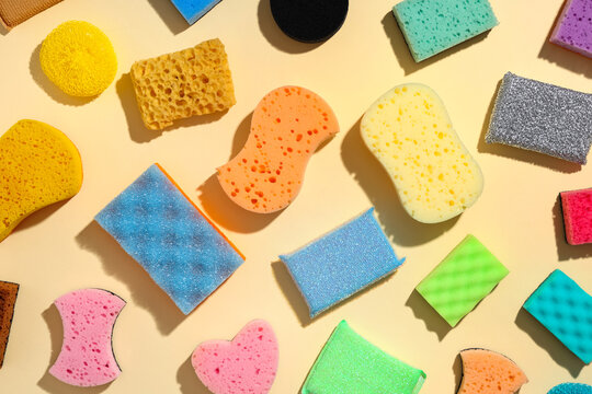 Assortment of colorful cleaning sponges and scrubbers for household chores and kitchen hygiene on a light background, the variety of textures and shapes are suitable for different household chores