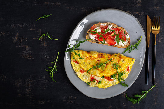 Healthy Omelet with Tomatoes and Arugula Served with Cream Cheese Toast