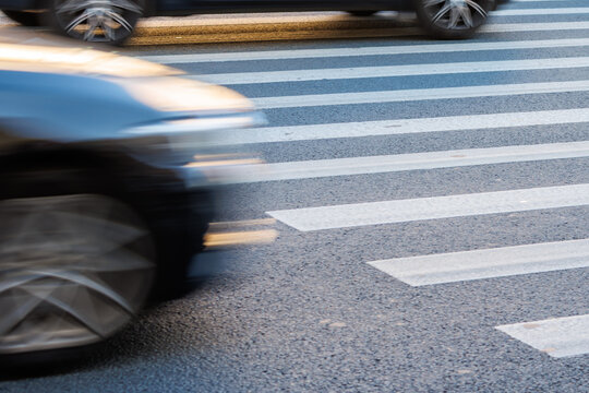 Car moves swiftly across zebra crossing