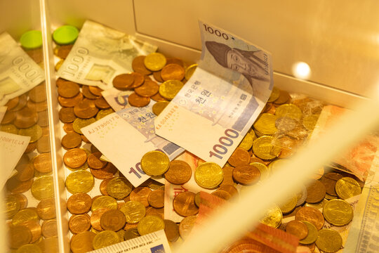 Donation box filled with international banknotes and coins for charity