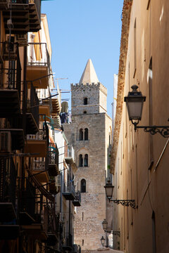 The Norman Cathedral of Cefalu stands majestically with its imposing stone facade.