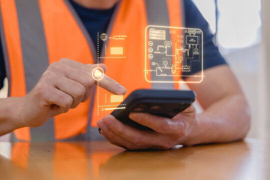 Industrial worker using a smartphone with digital interface for smart factory automation, IoT monitoring, cloud technology, data control, engineering systems modern industrial operations.