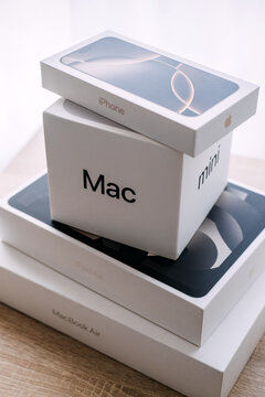 Stack of Apple product boxes on wooden table. Apple product unboxing, new apple devices boxes, unpacking apple tech purchase. Warsaw, Poland, 20 July 2026.