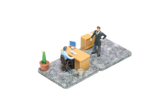 Miniature tiny people toy figure photography. Office complaint illustration concept. A businessman gives a warning to staff employee at office room