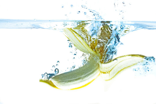 Pealed banana splashing into water