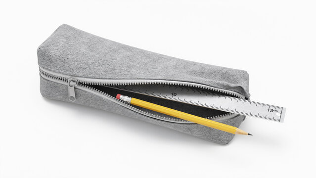 Gray fabric pencil case with zipper holding wooden pencil and metal ruler on white surface