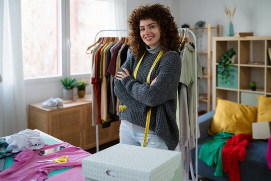 Fashion designer standing in creative workspace with confidence