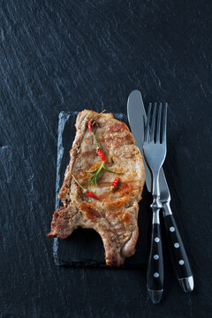 Pork collar cutlet on board with cutlery