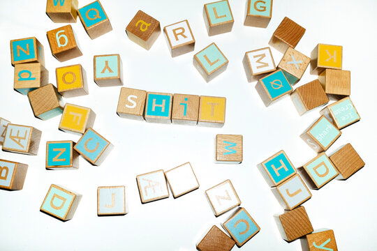 Wooden alphabet building blocks spell a message on a white surface