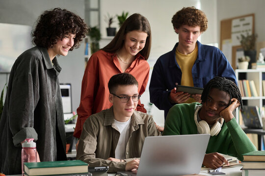 Diverse student team studies online using a laptop in the classroom