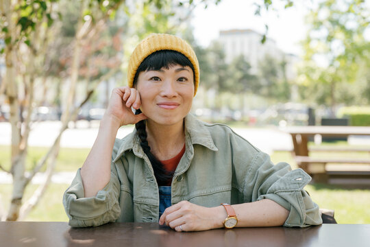 Woman sitting outdoors in casual outfit looking at camera