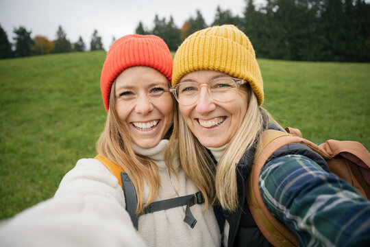 Two women friends take a selfie while hiking outdoors