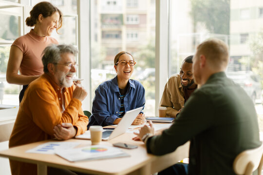 Smiling business team shares joy during an office meeting