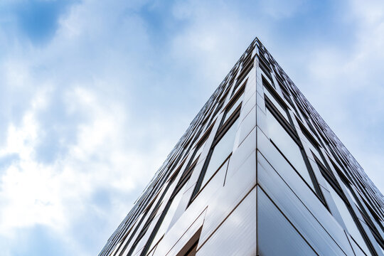 Modern glass skyscraper reaches into the cloudy sky in Hamburg