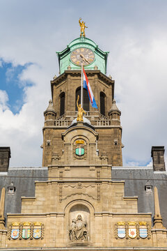 Clock tower of the Stadhuis city hall with golden statues in Rotterdam, Netherlands
