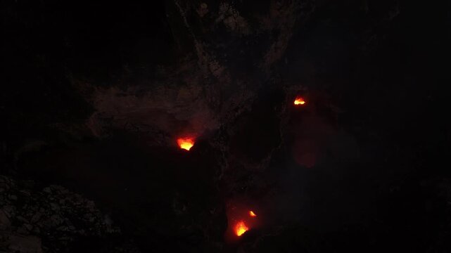 Incredible close-up aerial view of violent red glowing lava exploding, smoking caldera in extreme geological environment. Drone footage inside the active crater of Mount Yasur volcano, Tanna, Vanuatu